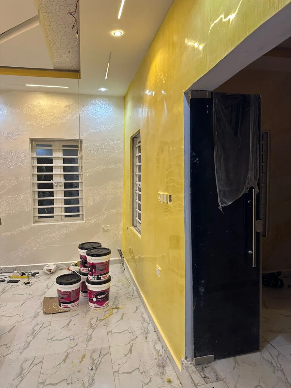 Gold accent corridor leading into a cream room