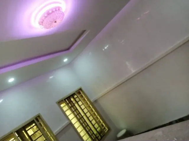 Pale ceiling finish illuminated by purple accent lighting