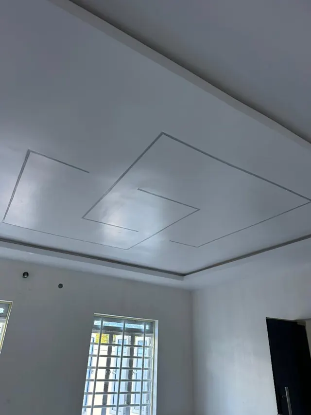 White recessed ceiling above a light neutral wall