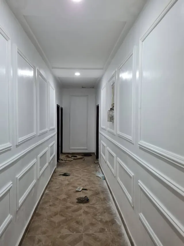 Crisp white corridor with repeated wall-panel moulding